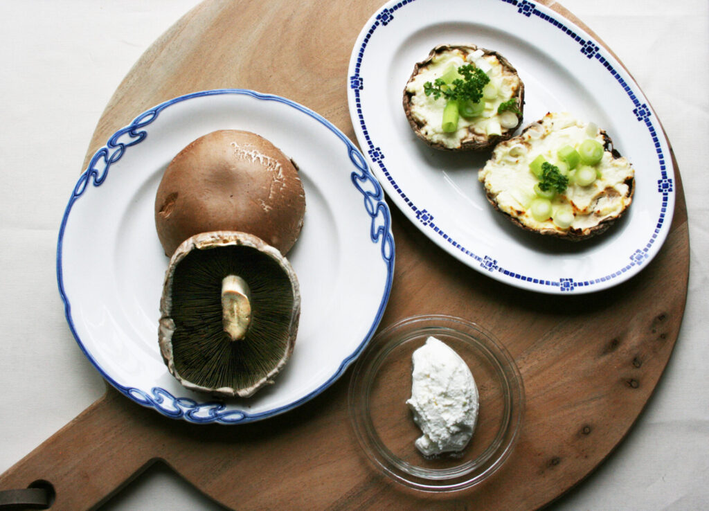 3 tallerkener, den ene med portobello svampe, den anden med ricotta ost og den sidste færdig bagte svampe klar til servering.